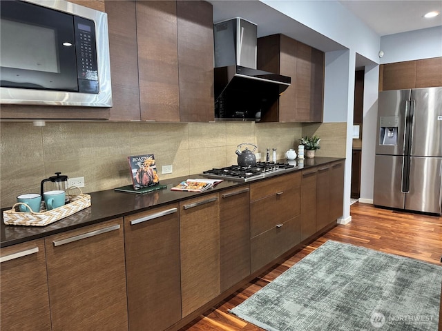 16486 SE 46th Ct, Bellevue, WA 98006 - kitchen featuring stainless steel appliances, wall chimney exhaust hood, dark countertops, wood finished floors, and modern cabinets