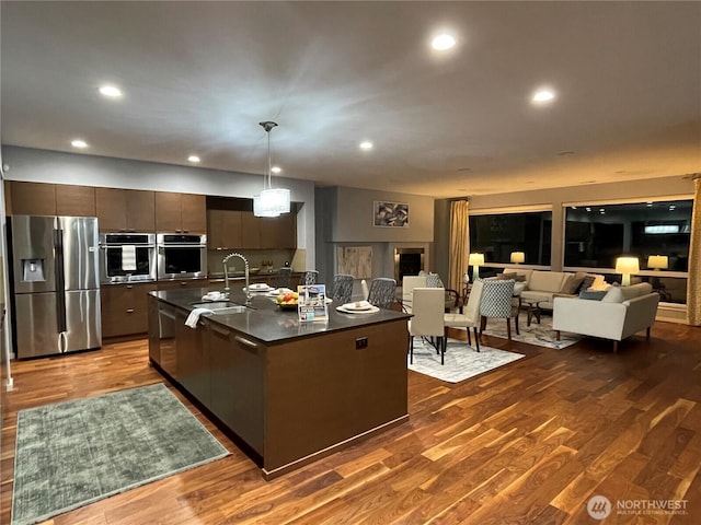 16486 SE 46th Ct, Bellevue, WA 98006 - kitchen with stainless steel fridge, dark countertops, modern cabinets, dark wood finished floors, and recessed lighting
