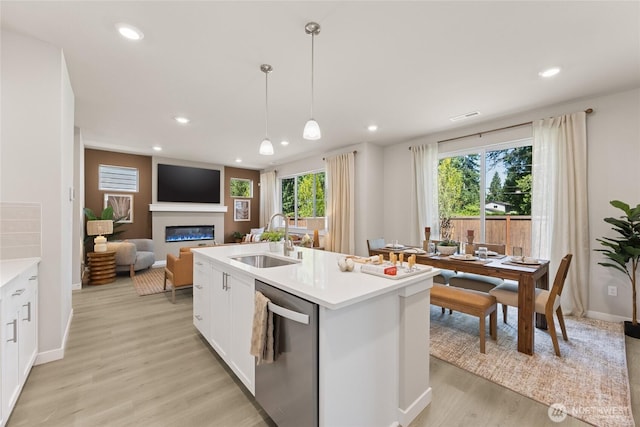 26808 NE 143rd Cir Unit 25, Duvall, WA 98019 - kitchen featuring dishwasher, recessed lighting, a glass covered fireplace, light wood-style floors, and white cabinetry