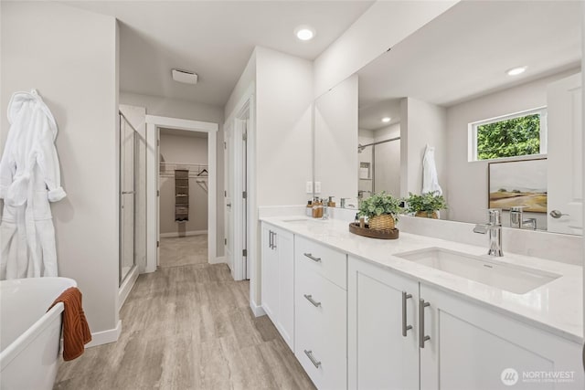 26808 NE 143rd Cir Unit 25, Duvall, WA 98019 - bathroom with a shower stall, double vanity, wood finished floors, a freestanding tub, and a walk in closet