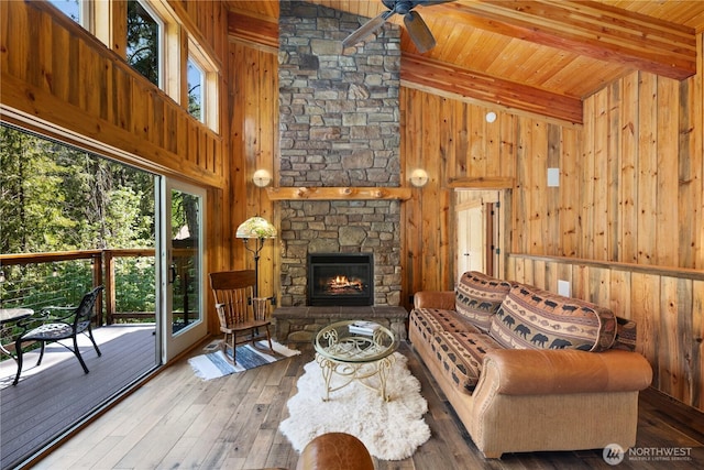 7189 Icicle Rd, Leavenworth, WA 98826 - living area featuring a ceiling fan, wood walls, a wood ceiling with exposed beams, a fireplace, and wood-type flooring