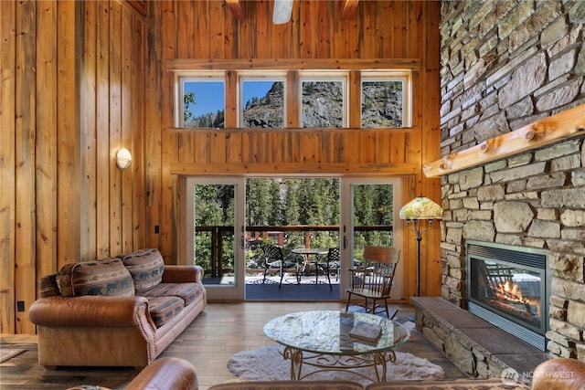 7189 Icicle Rd, Leavenworth, WA 98826 - living area featuring wood walls, a fireplace, plenty of natural light, a towering ceiling, and wood-type flooring