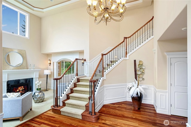 15025 SE 43rd St, Bellevue, WA 98006 - stairway with a high ceiling, wood finished floors, a high end fireplace, a chandelier, and wainscoting