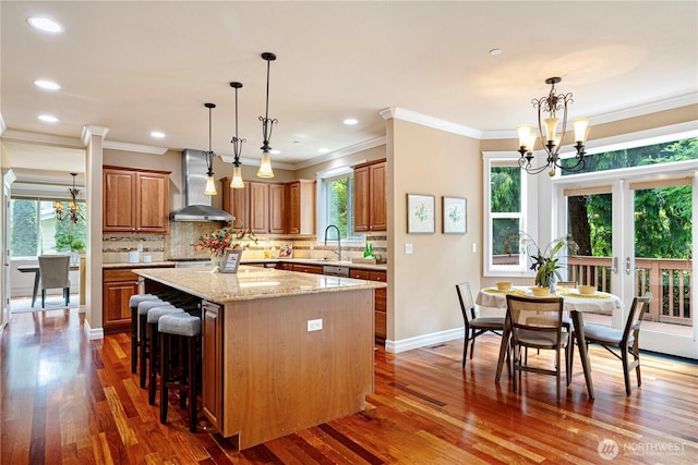 15025 SE 43rd St, Bellevue, WA 98006 - kitchen with wall chimney exhaust hood, a chandelier, a center island, dark wood-style flooring, and crown molding