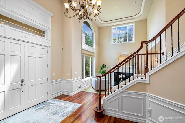 15025 SE 43rd St, Bellevue, WA 98006 - foyer featuring a chandelier, a wainscoted wall, stairway, dark wood-style flooring, and a decorative wall