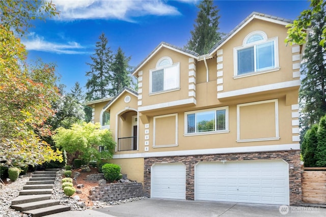 15025 SE 43rd St, Bellevue, WA 98006 - view of front facade with stucco siding, stone siding, a garage, and concrete driveway
