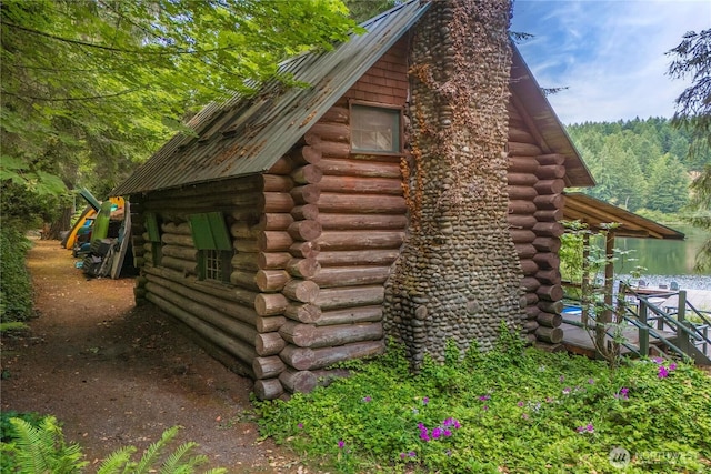 1546 Reservation Rd SE Unit 62, Olympia, WA 98513 - view of home's exterior with log exterior, a chimney, and a forest view