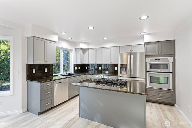 11511 188th St SE, Snohomish, WA 98296 - kitchen featuring stainless steel appliances, gray cabinets, dark stone countertops, backsplash, and plenty of natural light