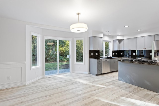 11511 188th St SE, Snohomish, WA 98296 - kitchen with stainless steel appliances, gray cabinetry, backsplash, light wood finished floors, and decorative light fixtures