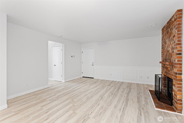 11511 188th St SE, Snohomish, WA 98296 - unfurnished living room with light wood-style flooring and a fireplace