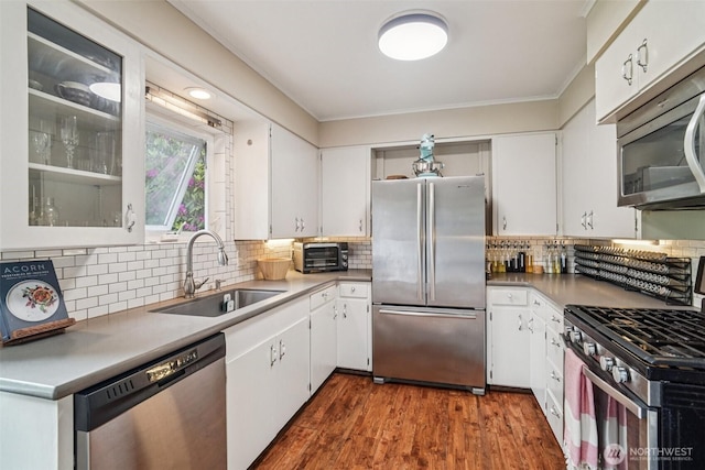 1209 Yew St, Bellingham, WA 98229 - kitchen featuring stainless steel appliances, white cabinets, backsplash, ornamental molding, and glass insert cabinets