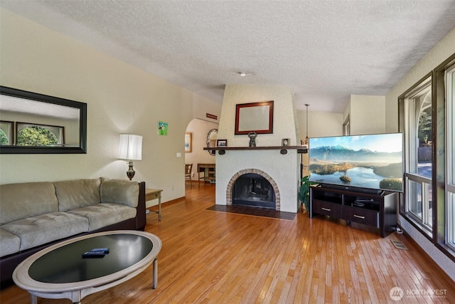 17837 Ashworth Ave N, Shoreline, WA 98133 - living area with a textured ceiling, arched walkways, hardwood / wood-style flooring, and plenty of natural light