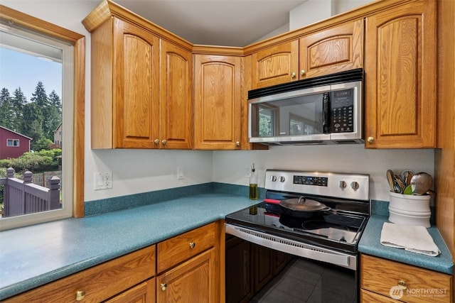 17837 Ashworth Ave N, Shoreline, WA 98133 - kitchen with stainless steel appliances, tile patterned floors, and brown cabinetry