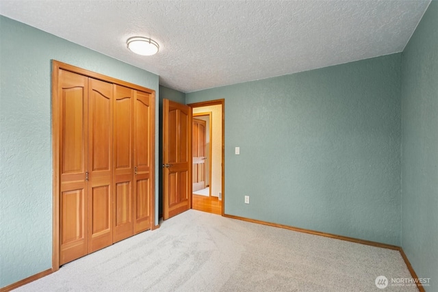 17837 Ashworth Ave N, Shoreline, WA 98133 - unfurnished bedroom featuring a textured wall, a textured ceiling, carpet floors, and a closet