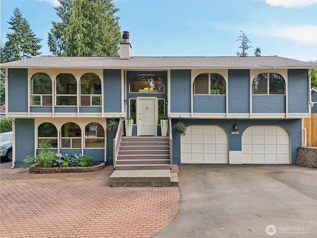 17837 Ashworth Ave N, Shoreline, WA 98133 - raised ranch featuring an attached garage, a chimney, asphalt driveway, stucco siding, and a porch