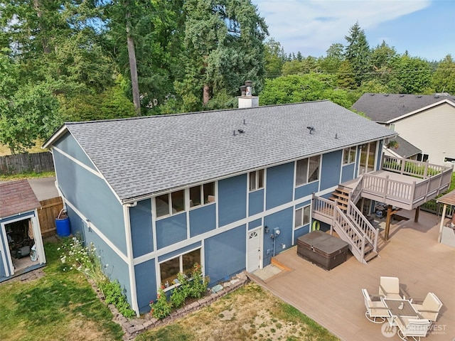 17837 Ashworth Ave N, Shoreline, WA 98133 - back of property with a wooden deck, a shingled roof, stucco siding, a hot tub, and a chimney