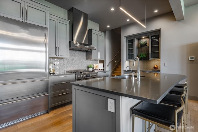 9424 Turnstone Ln Unit 29, Blaine, WA 98230 - kitchen featuring premium appliances, wall chimney exhaust hood, gray cabinetry, light wood-type flooring, and recessed lighting