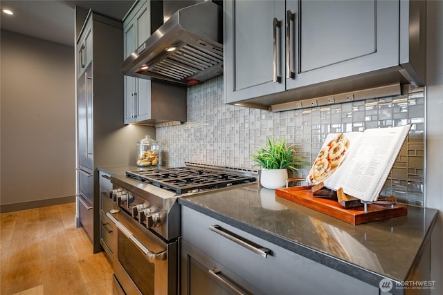 9424 Turnstone Ln Unit 29, Blaine, WA 98230 - kitchen featuring wall chimney range hood, stainless steel stove, light wood-style floors, backsplash, and recessed lighting