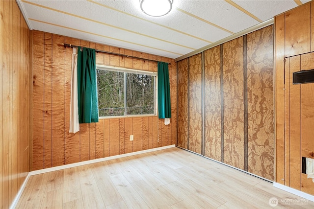 13632 SE 197th Pl, Renton, WA 98058 - spare room featuring wood finished floors, wood walls, and a textured ceiling