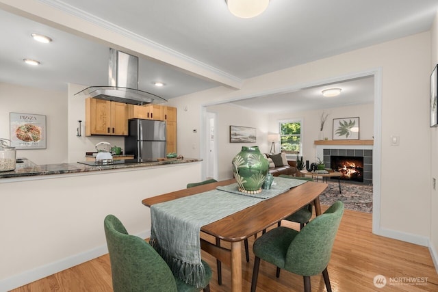 8051 30th Ave NW, Seattle, WA 98117 - dining space with light wood-type flooring, a tiled fireplace, and recessed lighting