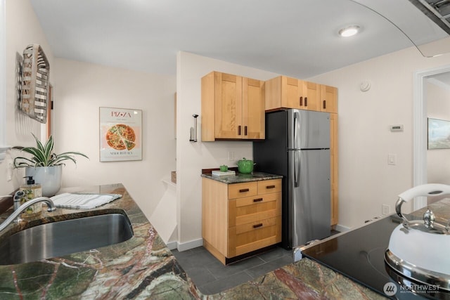 8051 30th Ave NW, Seattle, WA 98117 - kitchen with freestanding refrigerator, light brown cabinetry, dark tile patterned flooring, and dark stone countertops
