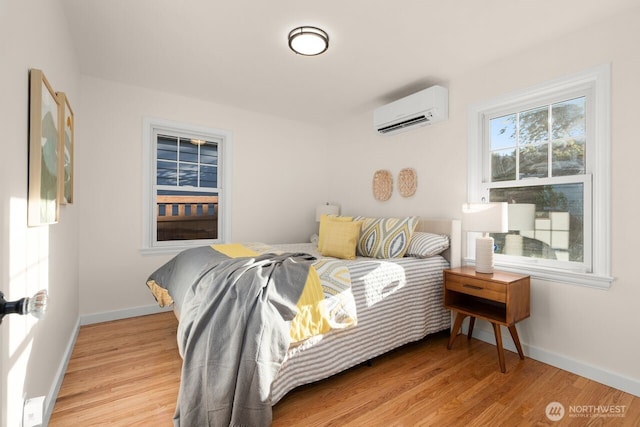 8051 30th Ave NW, Seattle, WA 98117 - bedroom featuring a wall mounted air conditioner and light wood-type flooring