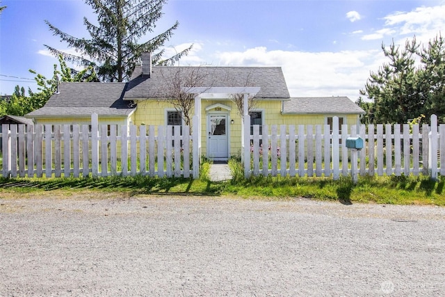 835 J St, Port Townsend, WA 98368 - view of front of house featuring a chimney, a fenced front yard, and a shingled roof