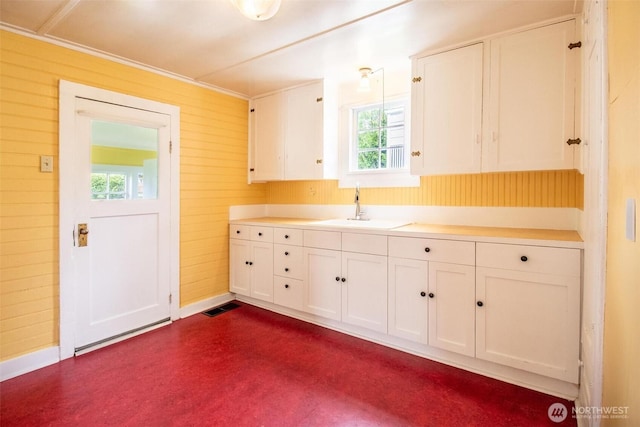 835 J St, Port Townsend, WA 98368 - kitchen with white cabinets, healthy amount of natural light, light countertops, and wood walls