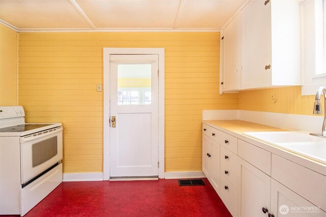 835 J St, Port Townsend, WA 98368 - kitchen with white electric range, white cabinets, wooden walls, light countertops, and crown molding
