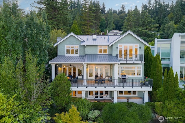 8066 Avalon Pl, Mercer Island, WA 98040 - rear view of house featuring a balcony, a standing seam roof, french doors, a metal roof, and a chimney