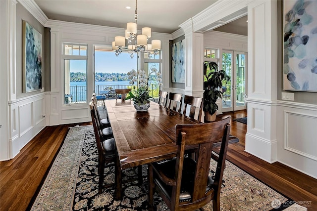 8066 Avalon Pl, Mercer Island, WA 98040 - dining area with a decorative wall, a chandelier, dark wood-type flooring, crown molding, and a water view