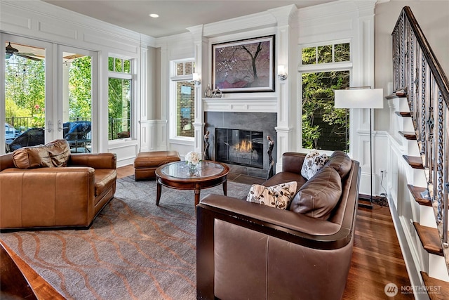 8066 Avalon Pl, Mercer Island, WA 98040 - living room featuring a decorative wall, stairs, a fireplace with flush hearth, wood finished floors, and french doors