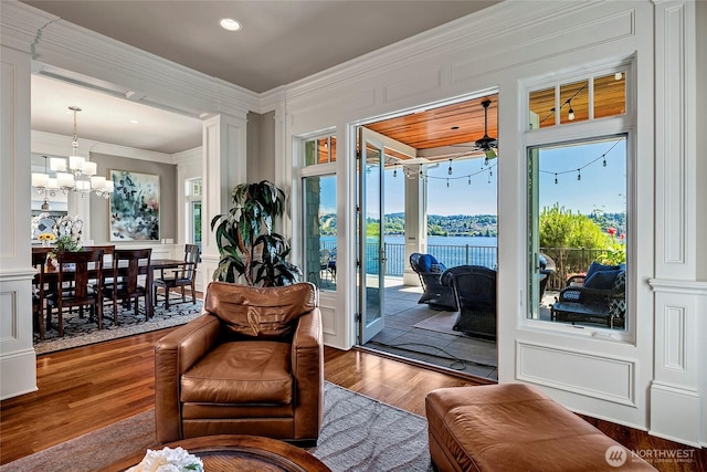 8066 Avalon Pl, Mercer Island, WA 98040 - living area featuring a decorative wall, crown molding, wood finished floors, a chandelier, and ceiling fan
