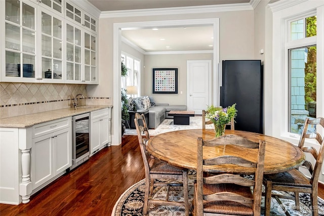 8066 Avalon Pl, Mercer Island, WA 98040 - dining room featuring wine cooler, dark wood-style flooring, wet bar, and crown molding