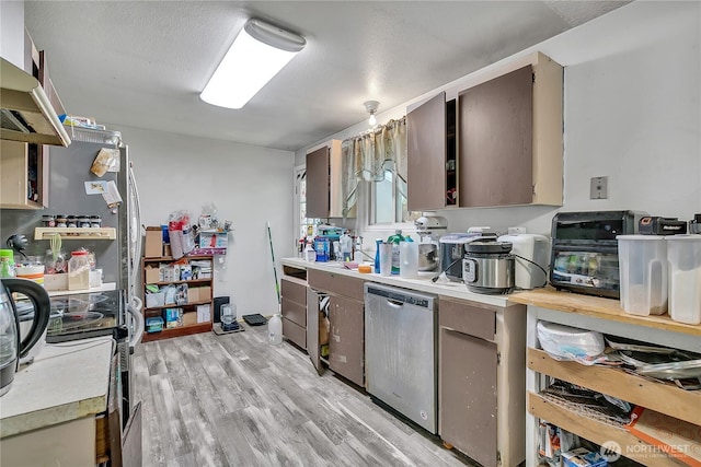 15414 121st Avenue Ct E, Puyallup, WA 98374 - kitchen featuring light countertops, stainless steel dishwasher, exhaust hood, light wood finished floors, and a textured ceiling