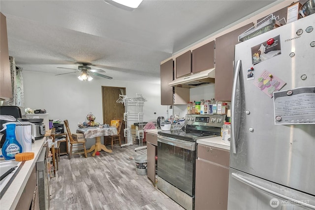 15414 121st Avenue Ct E, Puyallup, WA 98374 - kitchen with stainless steel appliances, under cabinet range hood, light countertops, a ceiling fan, and light wood finished floors