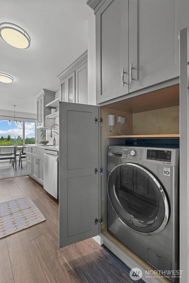 4545 Sand Point Way NE Unit 806, Seattle, WA 98105 - washroom with washer / clothes dryer, cabinet space, and wood finished floors