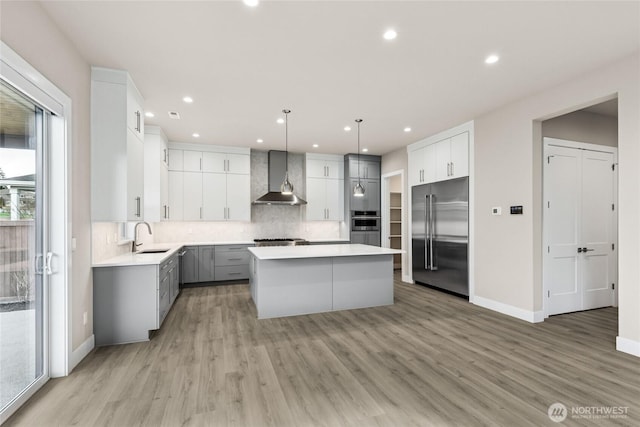 14449 133rd Pl NE, Woodinville, WA 98072 - kitchen with stainless steel built in fridge, wall chimney exhaust hood, a kitchen island, tasteful backsplash, and light wood-style flooring