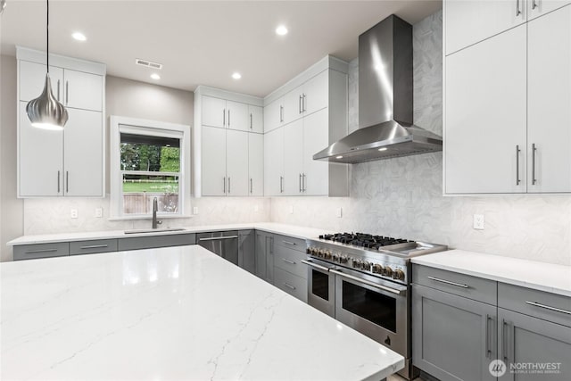 14449 133rd Pl NE, Woodinville, WA 98072 - kitchen with wall chimney exhaust hood, stainless steel appliances, gray cabinetry, light stone countertops, and recessed lighting