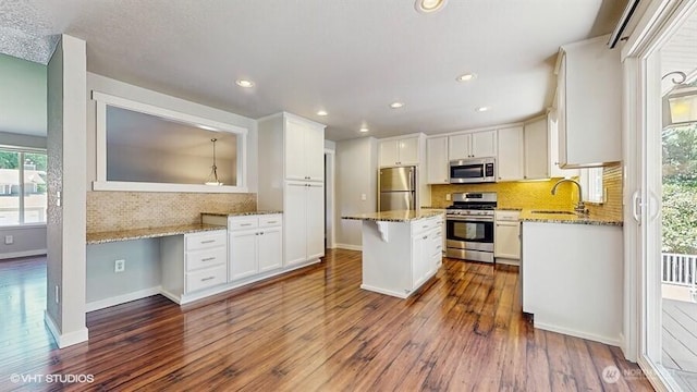 33700 33rd Pl SW, Federal Way, WA 98023 - kitchen featuring appliances with stainless steel finishes, dark wood finished floors, backsplash, white cabinets, and light stone counters