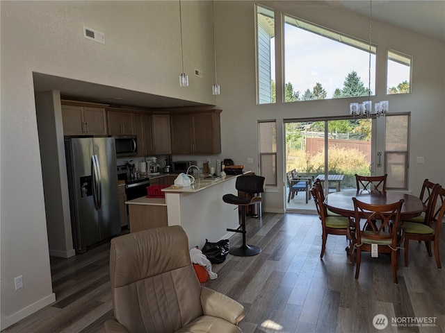 957 Twisp Carlton Rd Unit D, Twisp, WA 98856 - kitchen with appliances with stainless steel finishes, a towering ceiling, light countertops, wood finished floors, and a chandelier