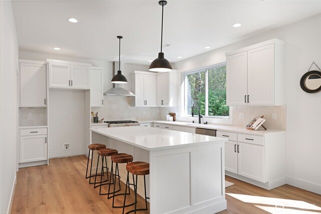 16806 62nd St SE, Snohomish, WA 98290 - kitchen featuring wall chimney range hood, tasteful backsplash, a center island, white cabinetry, and recessed lighting