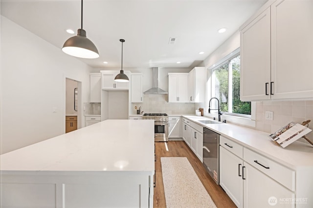 16806 62nd St SE, Snohomish, WA 98290 - kitchen featuring appliances with stainless steel finishes, wall chimney exhaust hood, wood finished floors, a center island, and tasteful backsplash