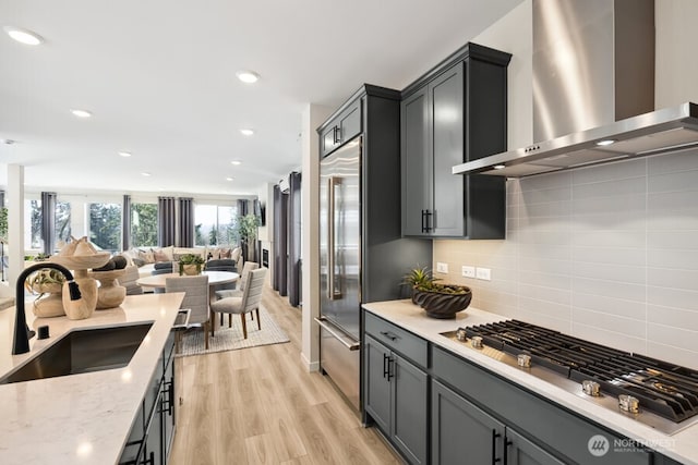4163 Aberdeen Way NE, Renton, WA 98056 - kitchen featuring wall chimney range hood, stainless steel appliances, open floor plan, light wood-style floors, and decorative backsplash