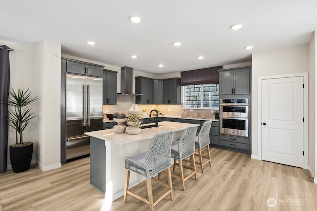 4163 Aberdeen Way NE, Renton, WA 98056 - kitchen with stainless steel appliances, wall chimney range hood, light countertops, light wood-type flooring, and recessed lighting