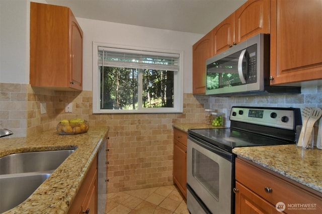13021 SE 38th St Unit J8, Bellevue, WA 98006 - kitchen with appliances with stainless steel finishes, light stone countertops, light tile patterned floors, and brown cabinetry