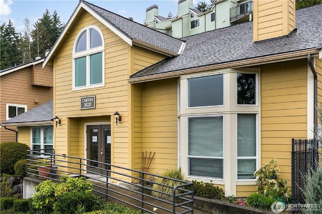 13021 SE 38th St Unit J8, Bellevue, WA 98006 - view of front of home featuring french doors, roof with shingles, and a chimney