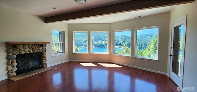 1936 Summit Lake Shore Rd NW, Olympia, WA 98502 - unfurnished living room featuring beam ceiling, wood finished floors, and a stone fireplace