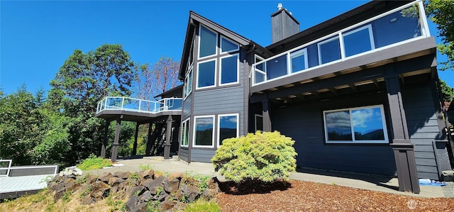 1936 Summit Lake Shore Rd NW, Olympia, WA 98502 - back of property featuring a chimney, a deck, a patio, and a balcony