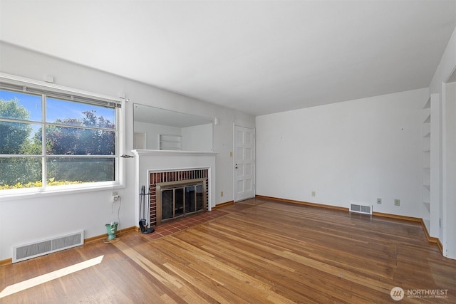 8403 36th Ave SW, Seattle, WA 98126 - unfurnished living room featuring a fireplace and wood finished floors
